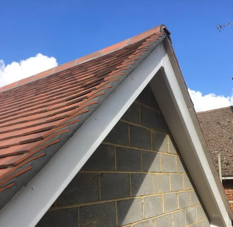 New white UPVC fascia and soffit boards with clay tile roof — roofline replacement in Surrey