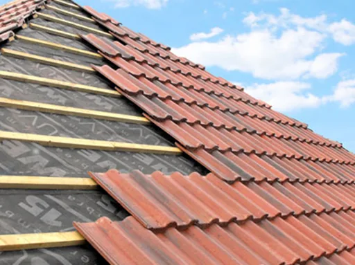 Close-up of interlocking roof tile installation showing felt, batten and tile layers — Never Felt Better Roofing